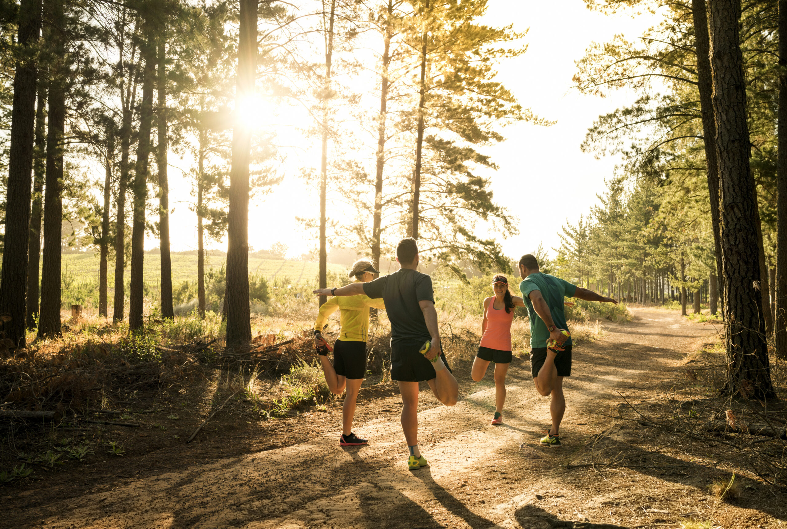 Friends stretching legs before jogging on road